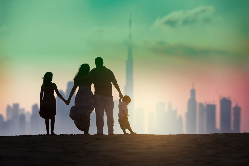 Dubai family on beach in front of skyline
